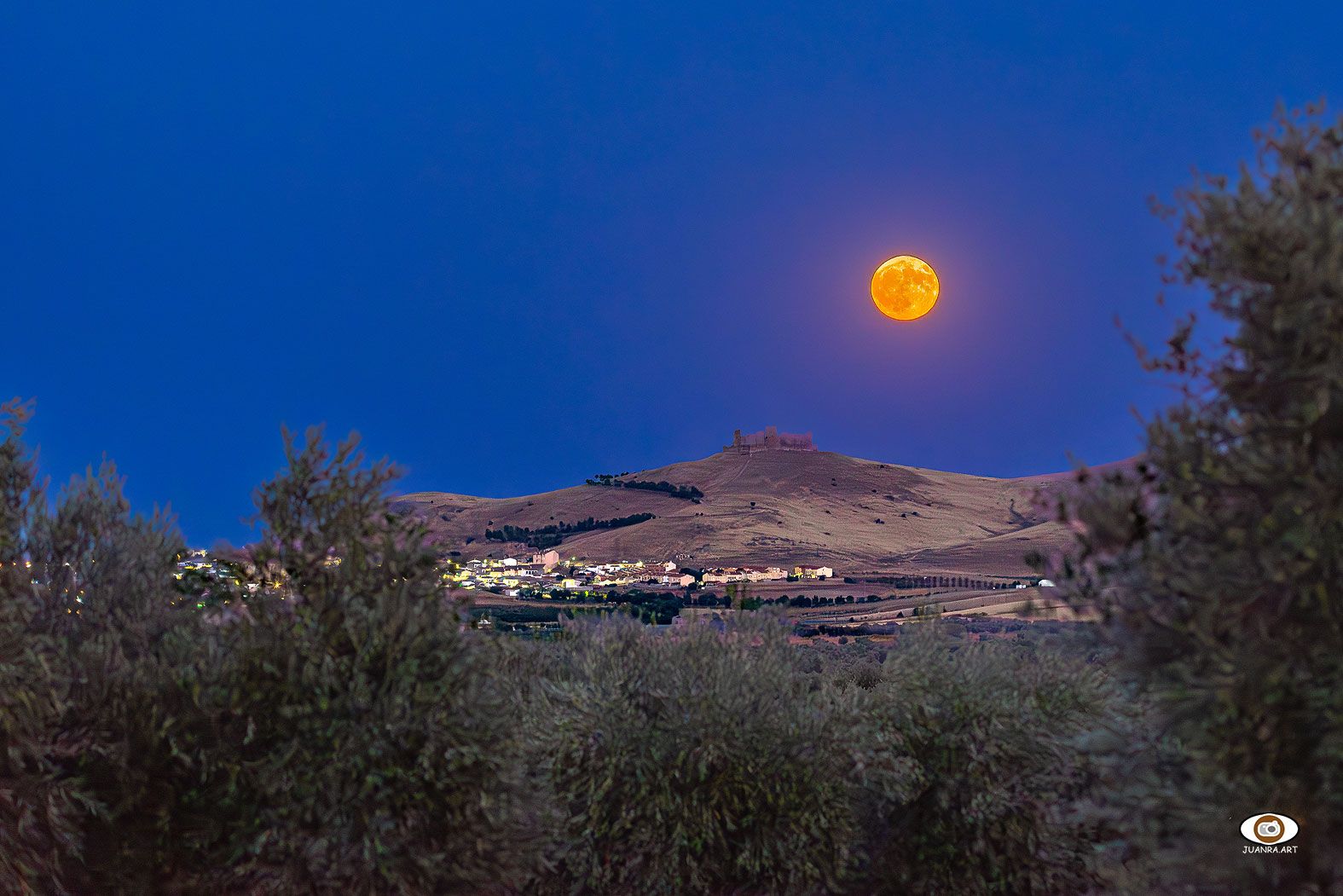 Vista de Almonacid y la luna desde el olivar.